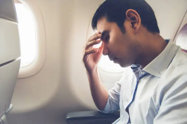 Photo of Male passenger having airsickness on the plane