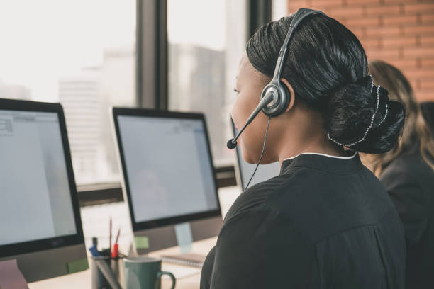 empresaria trabajando en un centro de llamadas - phoneline fotografías e imágenes de stock