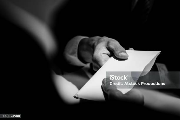 Businessman Giving Bribe Money In The Envelope To Partner Stock Photo - Download Image Now