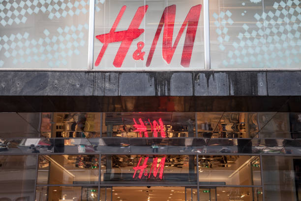 Logo of H&M reflecting on the ceiling of their main shop in Belgrade, above the main entrance. H&M is one of the biggest fashion retailers in Europe Picture of the logo of H&M taken in Serbia, reflecting on the roof. H & M, or Hennes & Mauritz is a Swedish multinational clothing-retail company, known for its fast-fashion clothing. h and m stock pictures, royalty-free photos & images