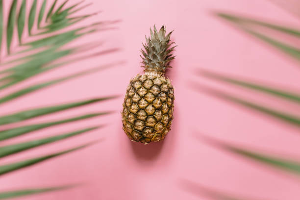istock Ripe pineapple on pastel pink background 1005145348