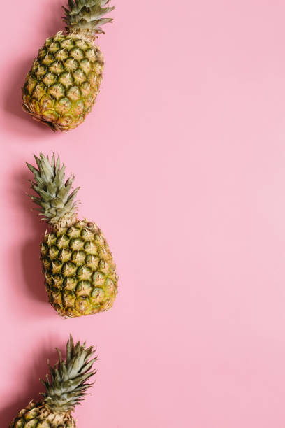 istock Ripe pineapple on pastel pink background 1005145350