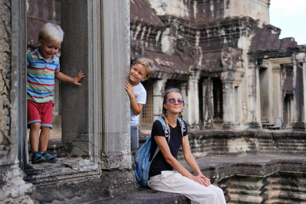 famille de touristes heureux, la mère et deux enfants dans le temple d’angkor - cambodia traditional culture ancient angkor photos et images de collection