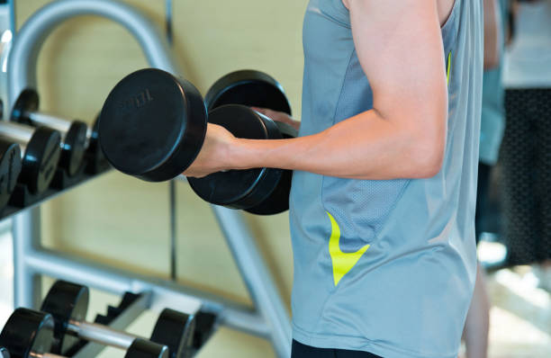 istock Man hand lifting dumbbells at gym 1005216504