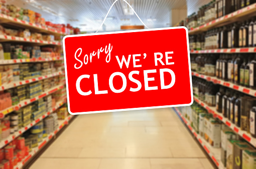 Sorry we are closed label on a blur Supermarket background