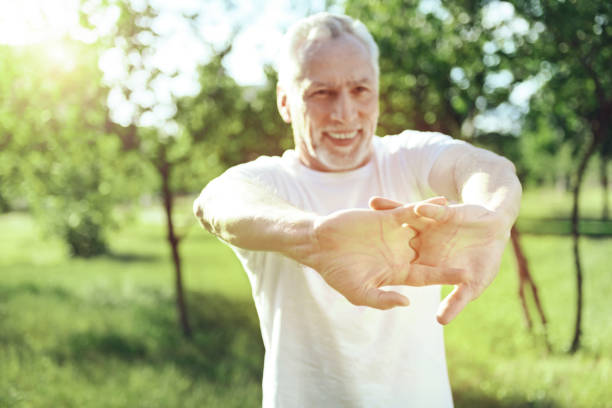 istock Glad old man showing his strength at the training 1005234730