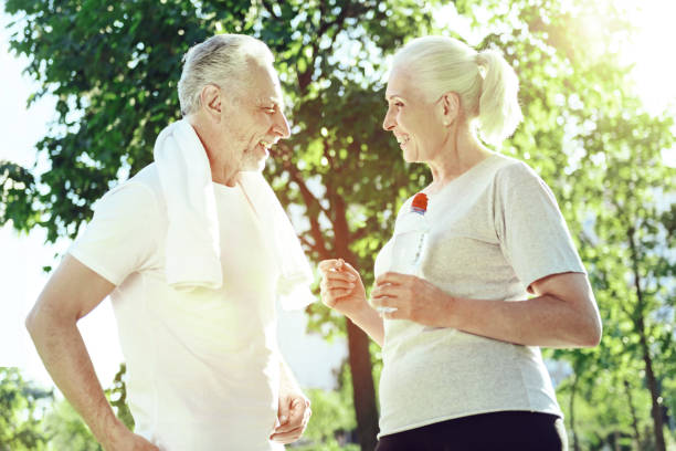 istock Two senior people talking in a park 1005234924