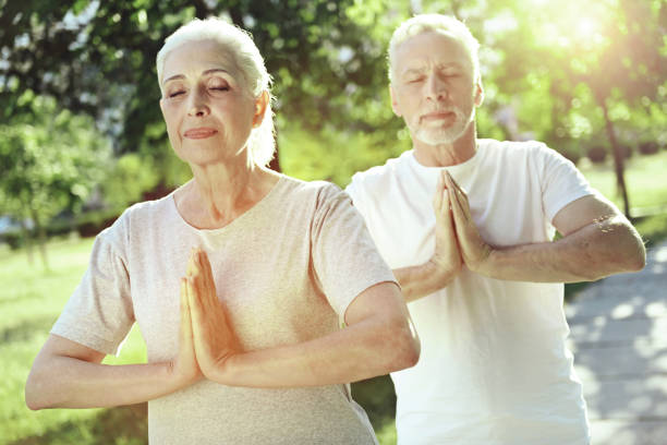istock Lovely aged couple meditating together 1005234992