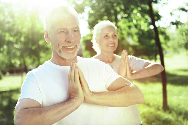 istock Happy aged people doing yoga exercises 1005235000