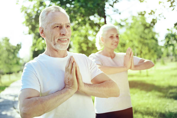 istock Healthy aged people practicing yoga together 1005235004