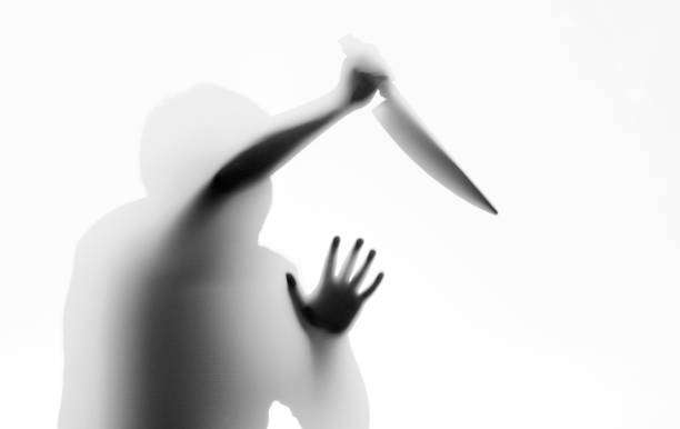 Man holding a knife behind the frosted glass.