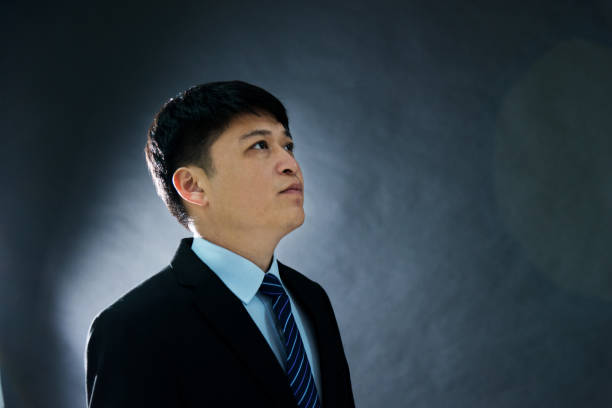 istock Side view of businessman on black background 1005245780
