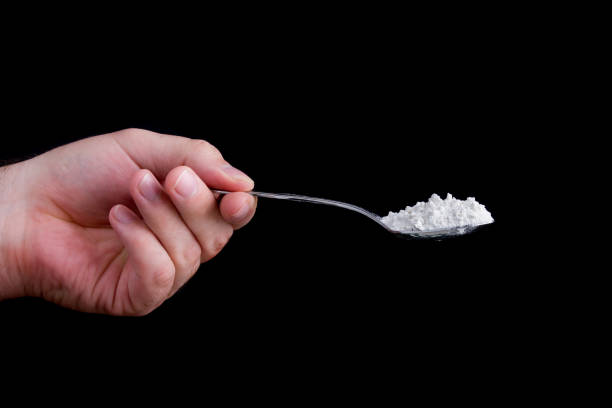 istock Hand holding a spoon full of a white powder 1005251466