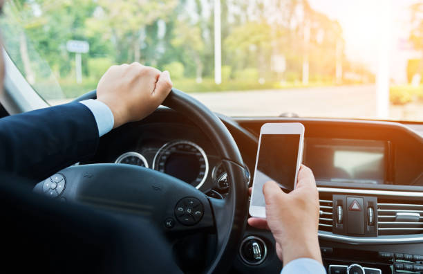 istock Businessman driving a car and using smart phone 1005254454