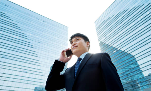 istock Businessman talking on mobile in front of office building 1005254710