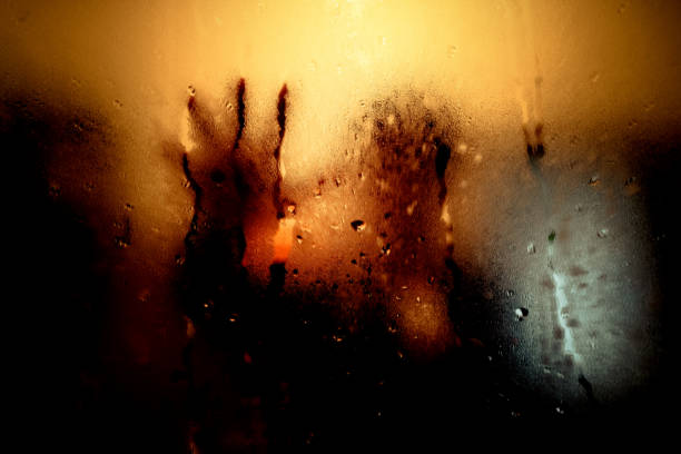 istock Dark room, mysterious man looking his reflection in a mirror. 1005257408