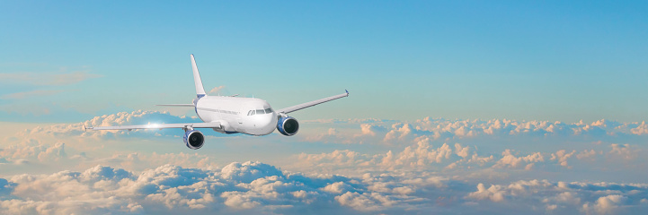 Passenger aircraft cloudscape with white airplane is flying in the evening sky cumulus clouds, panorama view
