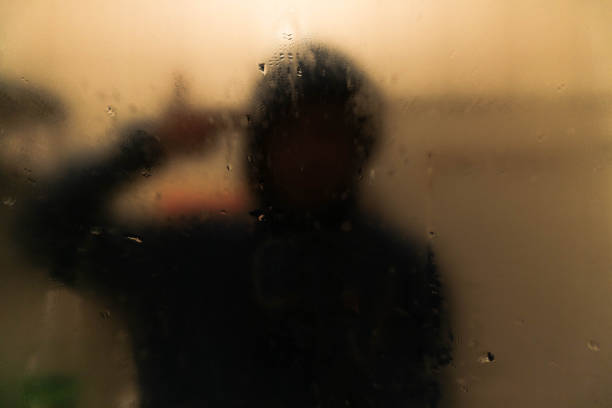 istock Dark room, mysterious man looking his reflection in a mirror. 1005259750