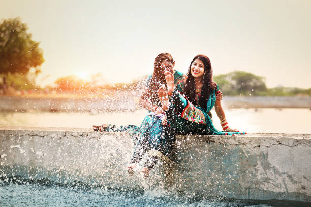 woman doing fun on vacations Two young friends doing full fun with lake water on vacations during sunset time outdoors. soaked suit stock pictures, royalty-free photos & images