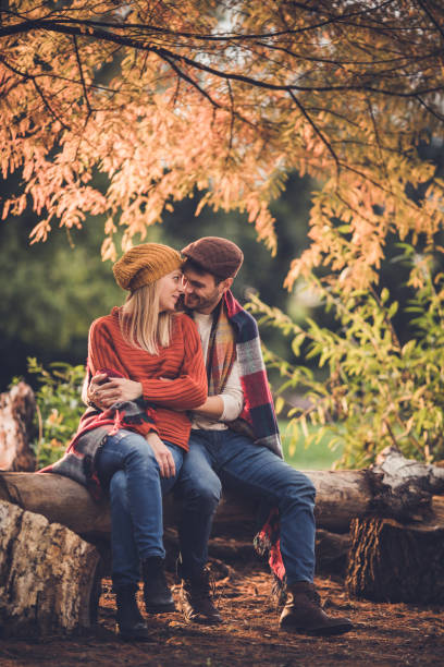 istock Young loving couple covered talking during autumn day in nature. 1005275818