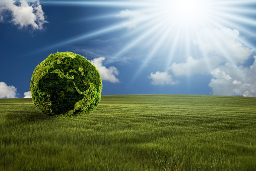 conceptual. Landscape with green lawn, blue sky and the sun shining on an ecological world.
