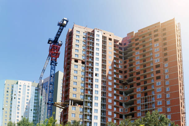 istock High-rise buildings under construction and building crane 1005320018