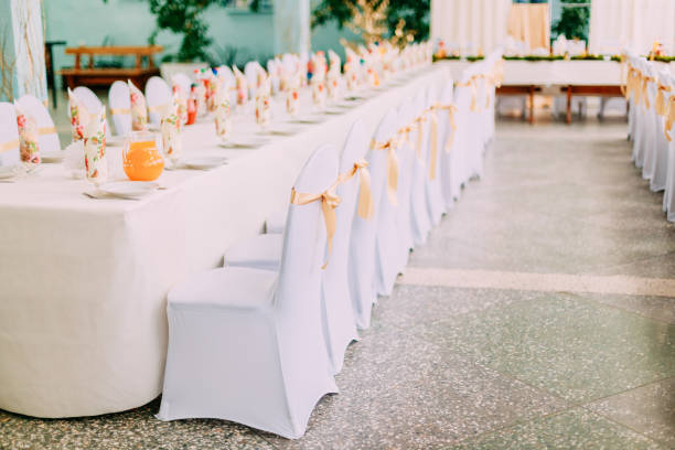 istock Decorative White Mantles And Colored Ribbons On Chairs At Festive Table. 1005327912