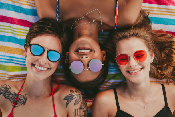 istock Close up of women relaxing on beach 1005330920