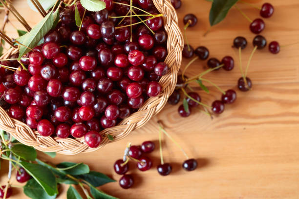 ripe juicy cherries in basket on a wooden background. - 7583 imagens e fotografias de stock