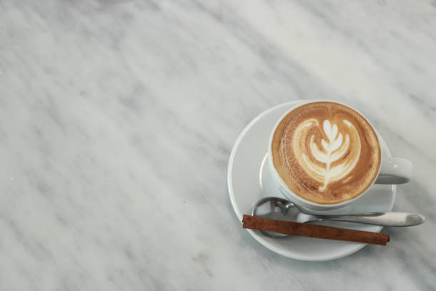 istock cup of coffee in a white cup on Marble desk background 1005339890