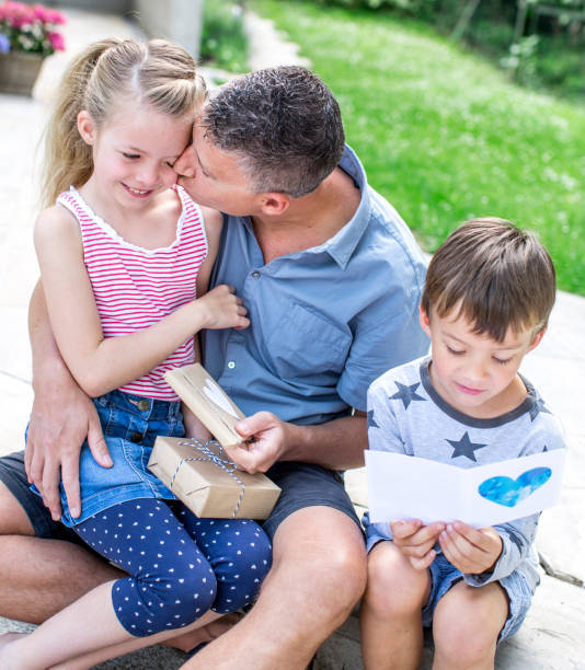 istock High Angle View Of Father With Children Sitting In Yard 1005340496