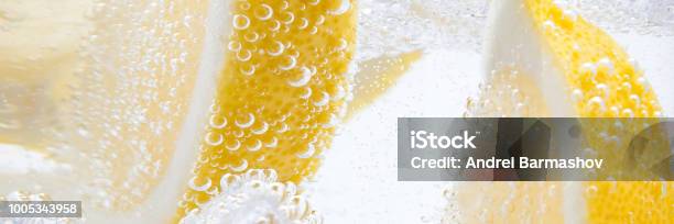 In A Glass With Cubes Of Melting Ice Slices Of A Juicy Lemon Stock Photo - Download Image Now