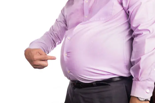 Photo of Man pointing own unhealthy big belly with visceral subcutaneous fats