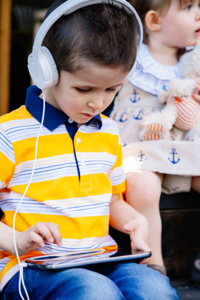 istock Siblings listening to music and smiling 1005348276