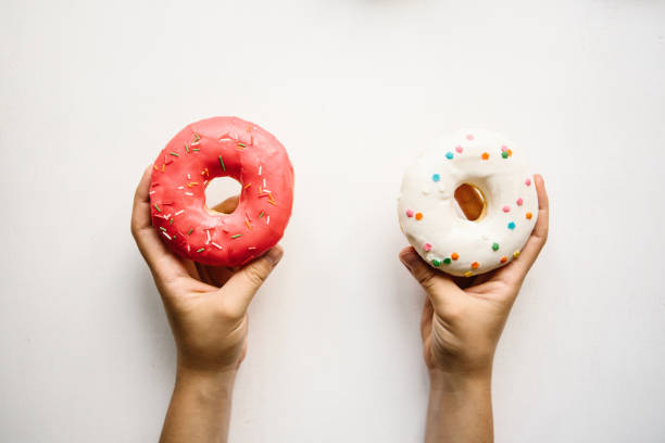 istock The girl is holding donuts in her hands on a white background 1005349658