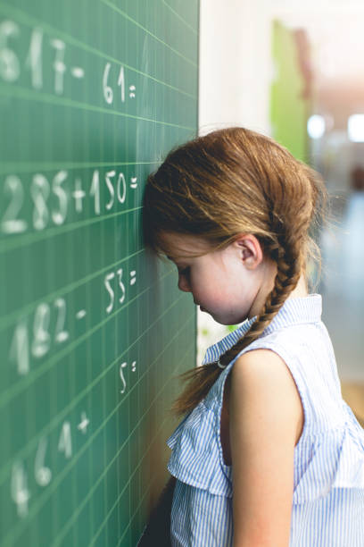 istock Side View Of Girl Leaning On Blackboard At Classroom 1005352948