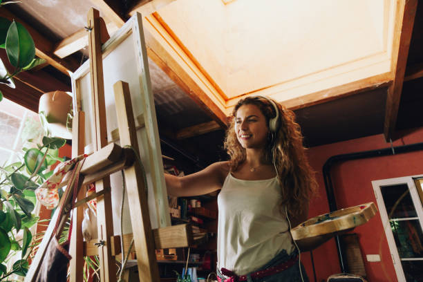 istock Woman painter painting in her painting studio. 1005359768