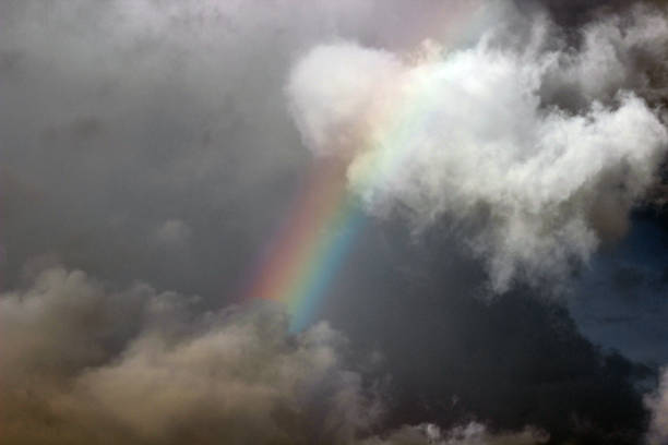 rainbow in dark and bright cloudy sky - every cloud has a silver lining imagens e fotografias de stock