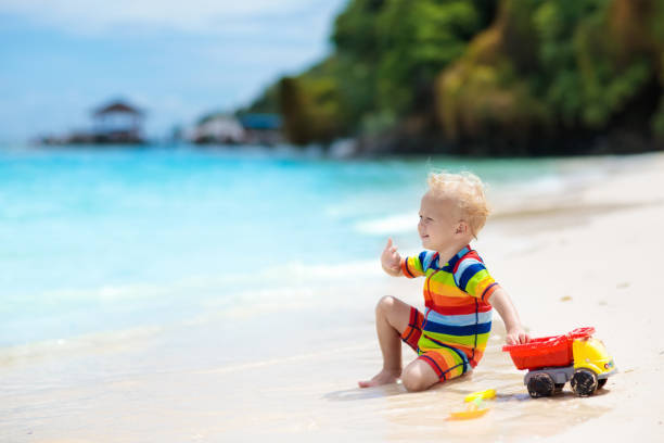 istock Kids play on tropical beach. Sand and water toy. 1005384314