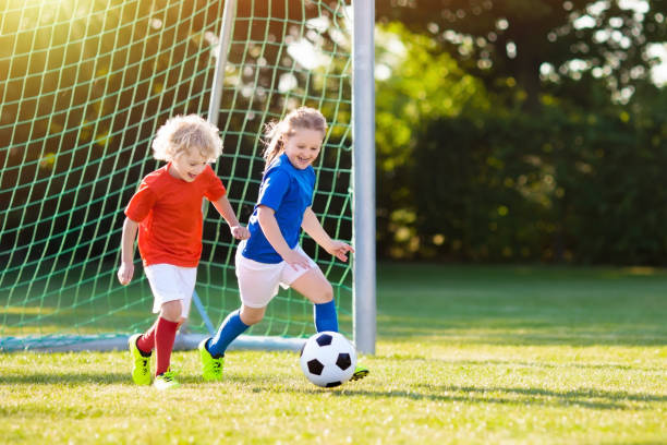 i bambini giocano a football. bambino al campo da calcio. - termine sportivo foto e immagini stock