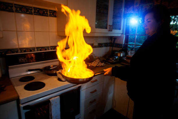 koch macht flambiertem in einer pfanne erhitzen, wodurch eine große flamme - ready to cook flash stock-fotos und bilder