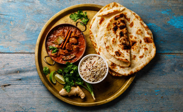 Chicken tikka masala spicy curry meat food with rice and naan bread Chicken tikka masala spicy curry meat food with rice and naan bread on wooden background indian food stock pictures, royalty-free photos & images
