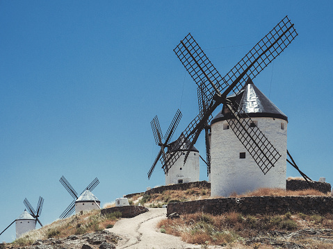 Ancient traditional windmills in Consuegra Toledo province Spain. Hundreds of those windmills where spread across La Mancha and they were the inspiration for the famous chapter of Don Quixote fighting the windmills thinking they were giants