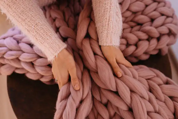 Photo of Girl hands holding warm pink blanket