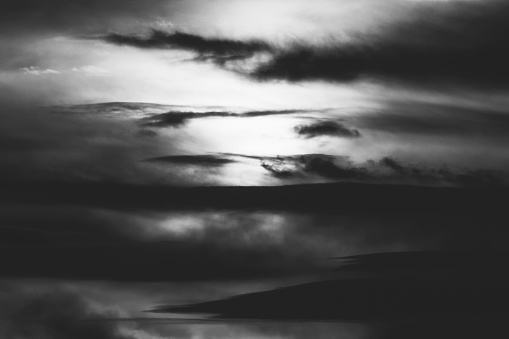 winter sunset in the evening sky with clouds, black and white photo