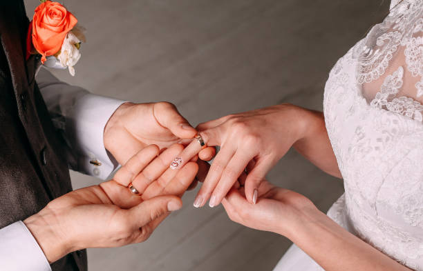 istock Wedding ceremony bride groom putting golden rings 1005439714