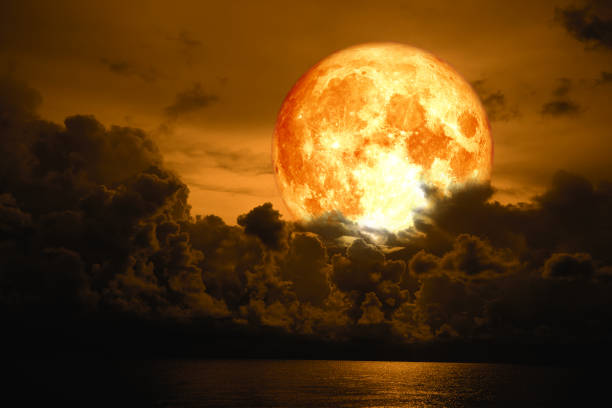 istock full blood moon over silhouette heap cloud on the sea 1005444344