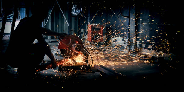 istock Worker cutting metal with grinder. Sparks while grinding iron 1005449746