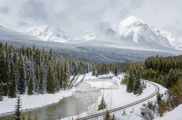 istock Winter Mountain Landscape with a Railway Running alongside a Frozen River 1005449786