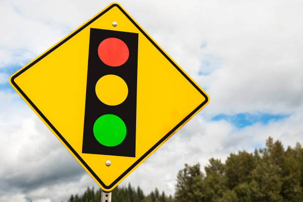 istock Traffic Lights Ahead Road Sign against Cloudy Sky 1005450268
